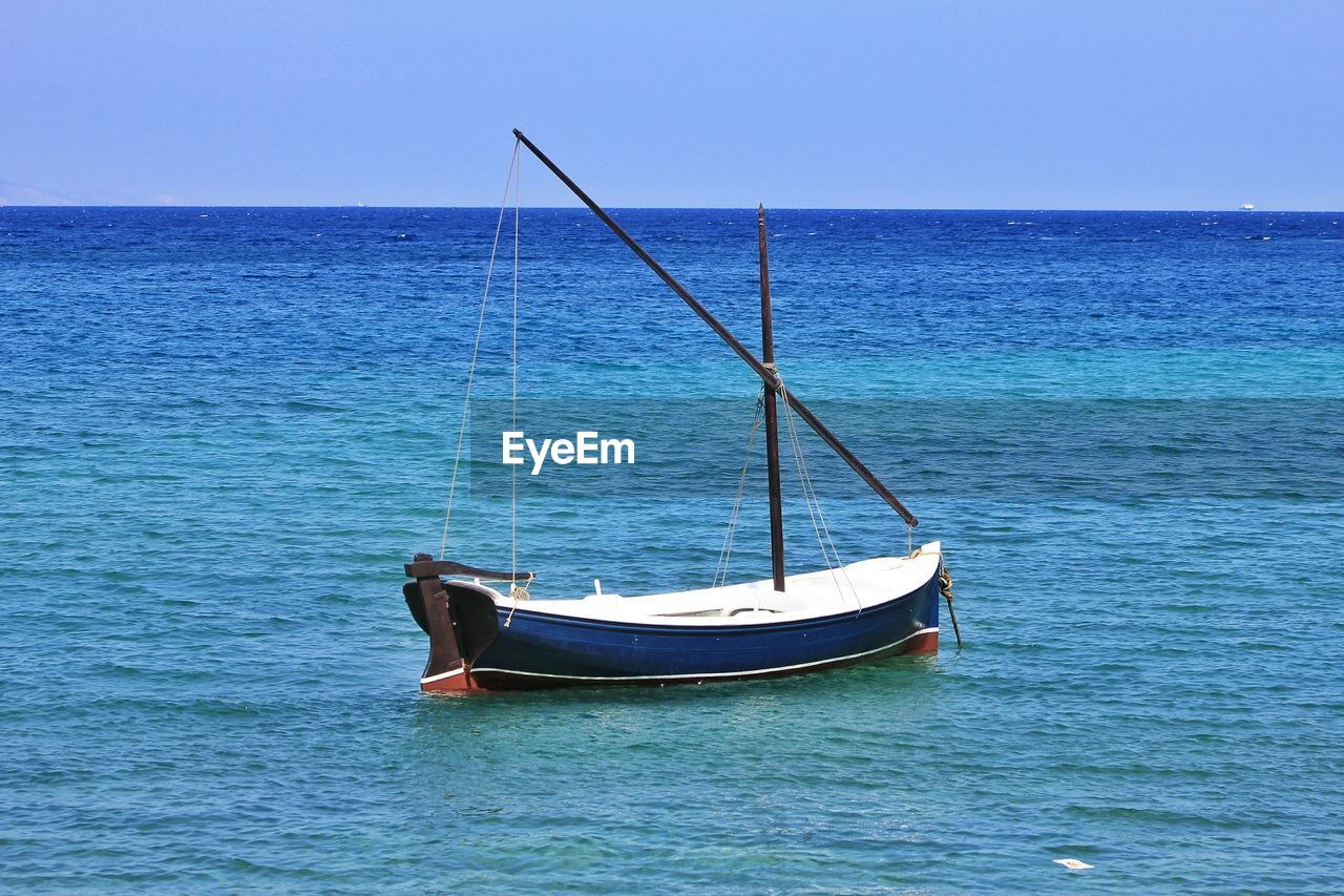 Boat moored on sea against sky