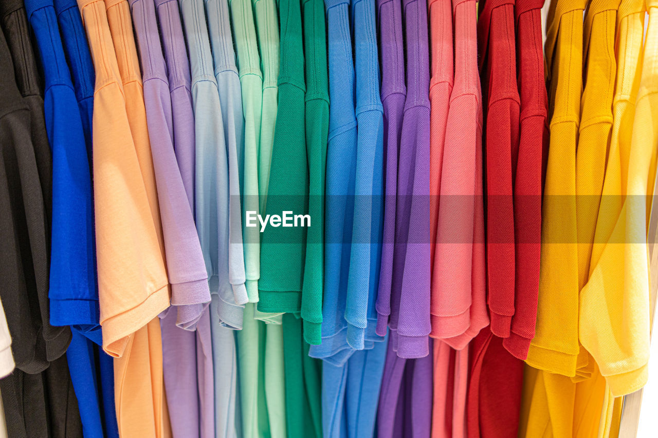 Multi colored clothes hanging on rack in store