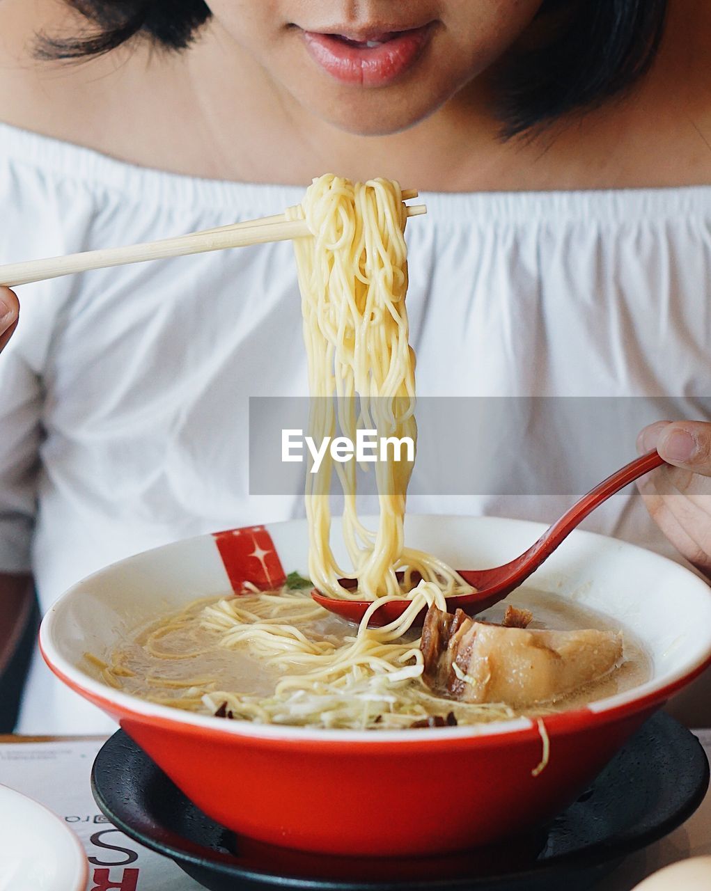 Close-up of woman eating noodles