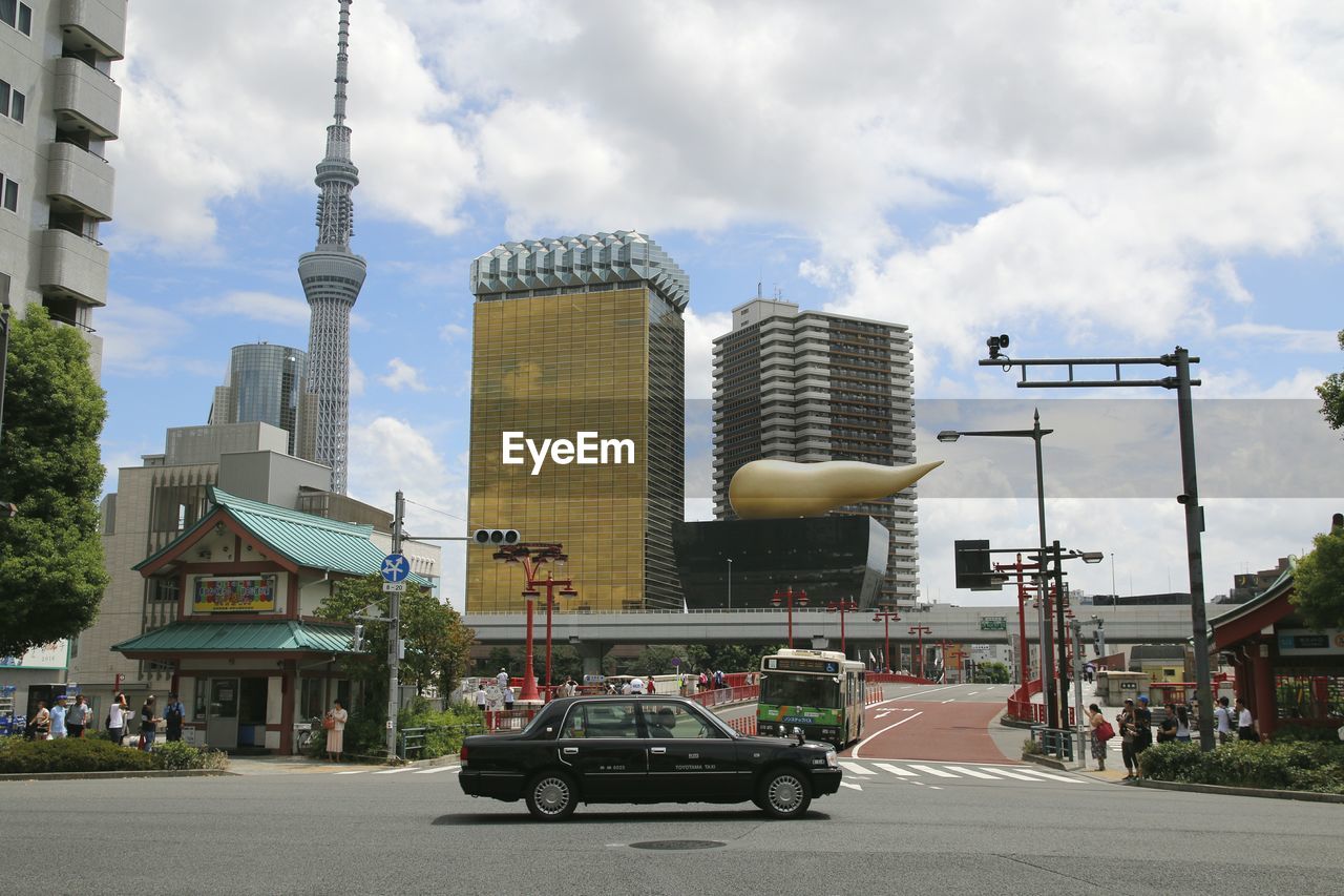 Cars on road against sky in city