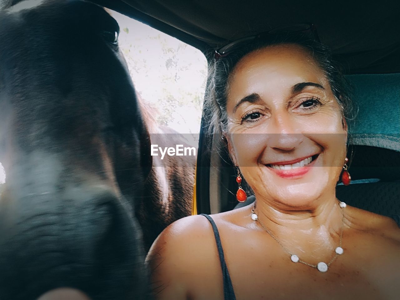 PORTRAIT OF HAPPY WOMAN IN CAR