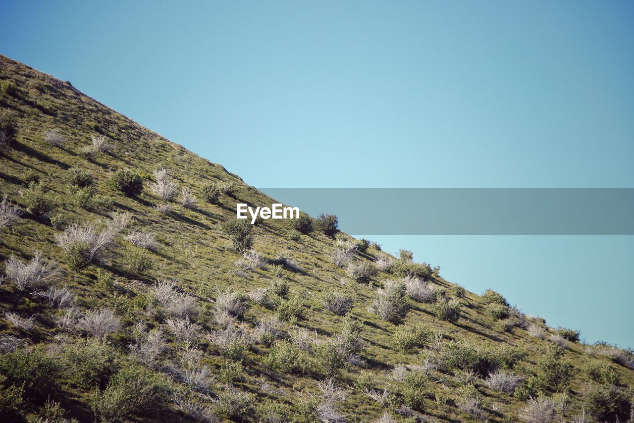 Low angle view of mountain against clear blue sky