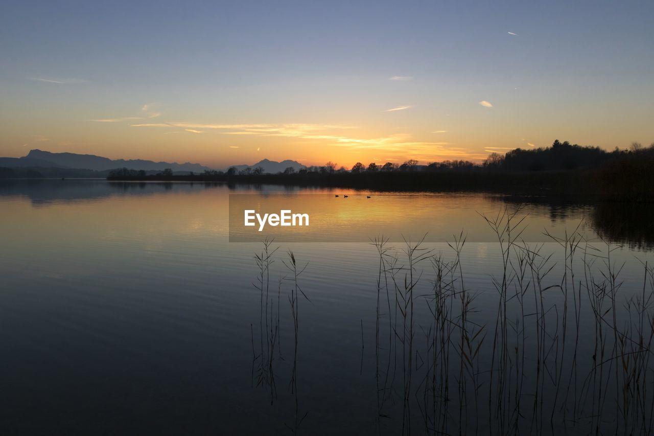 Scenic view of lake against sky during sunset