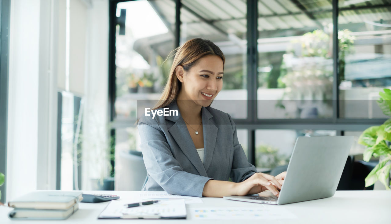 portrait of businesswoman using laptop at office