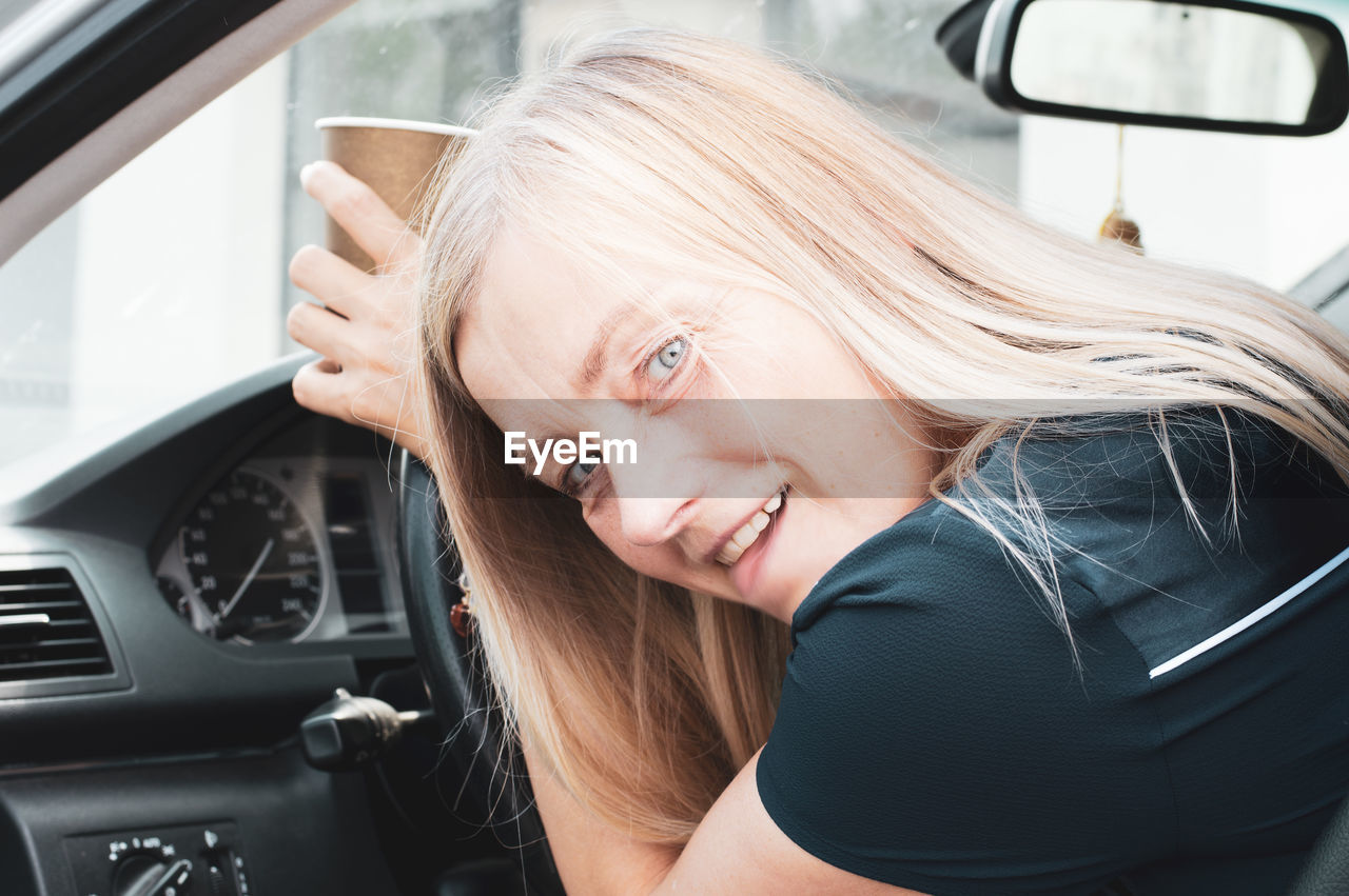 Portrait of young woman in car