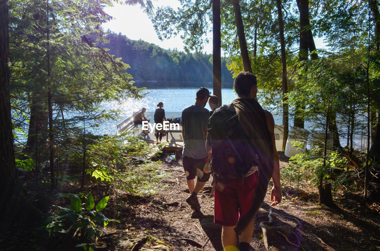 REAR VIEW OF PEOPLE WALKING ON LAND