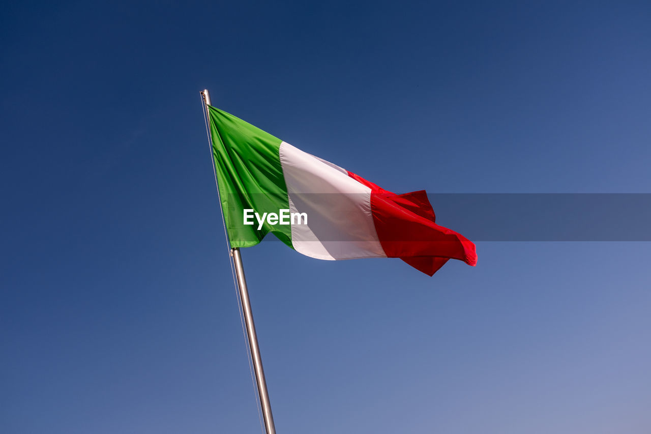 Low angle view of italian flag against clear blue sky