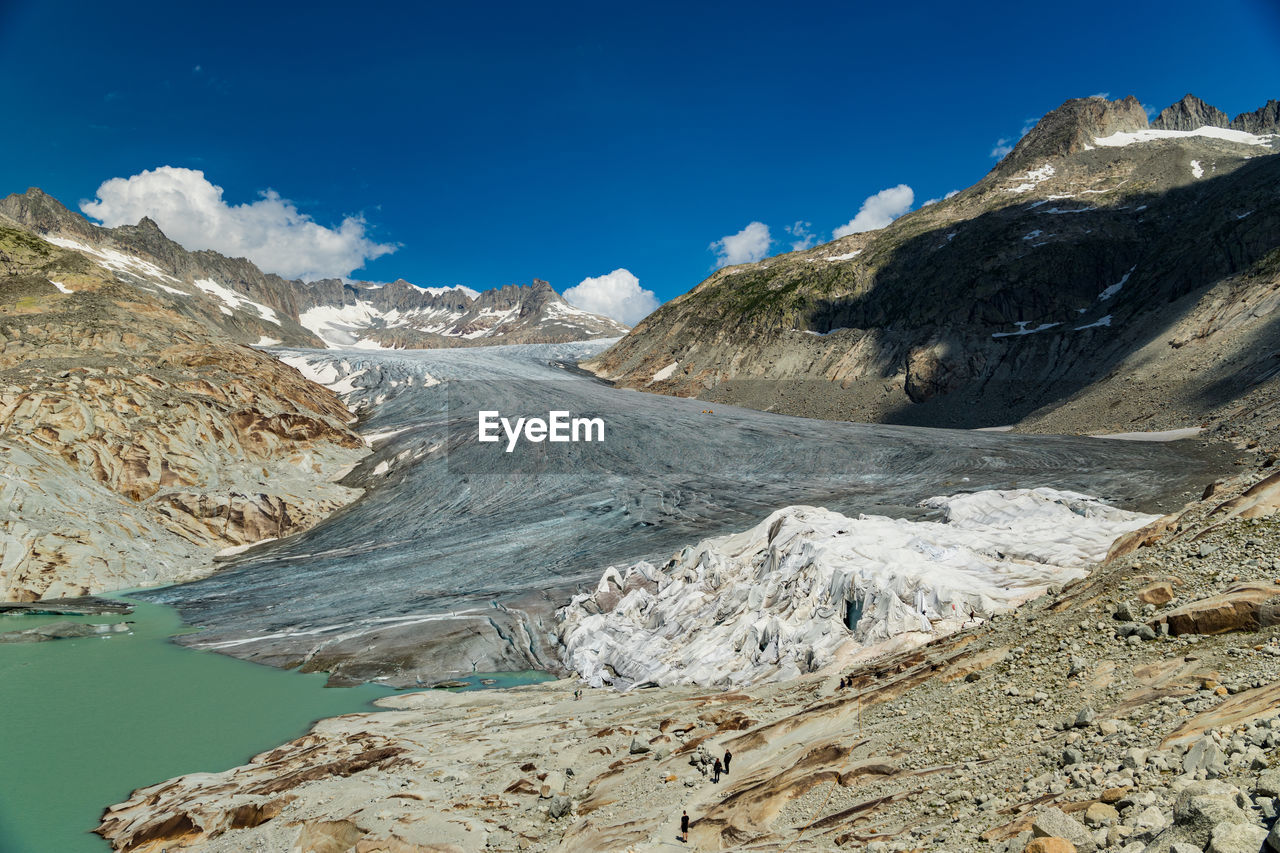 Scenic view of snowcapped mountains against blue sky