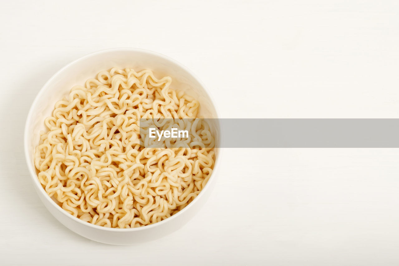 Instant noodles are placed in a white cup.