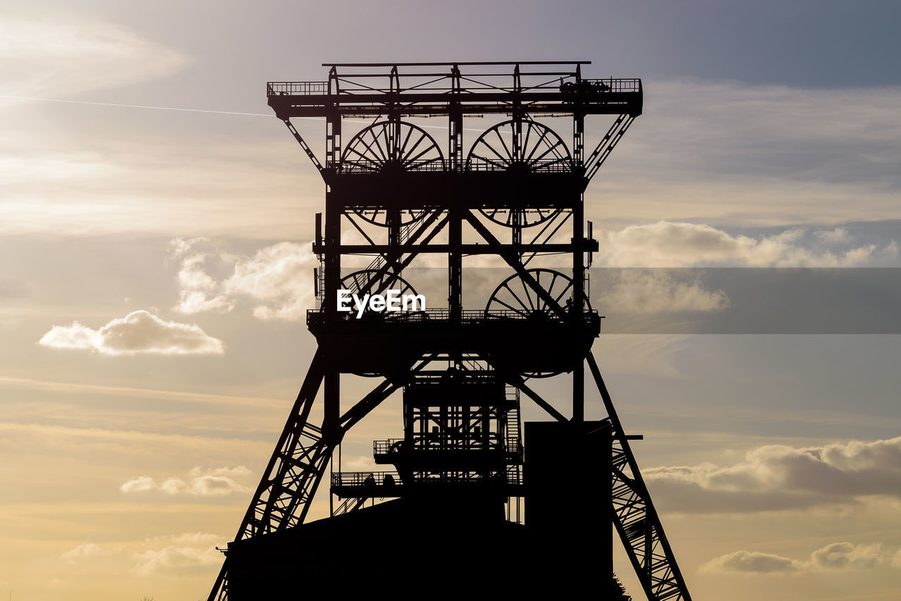 low angle view of silhouette electricity pylon against sky during sunset