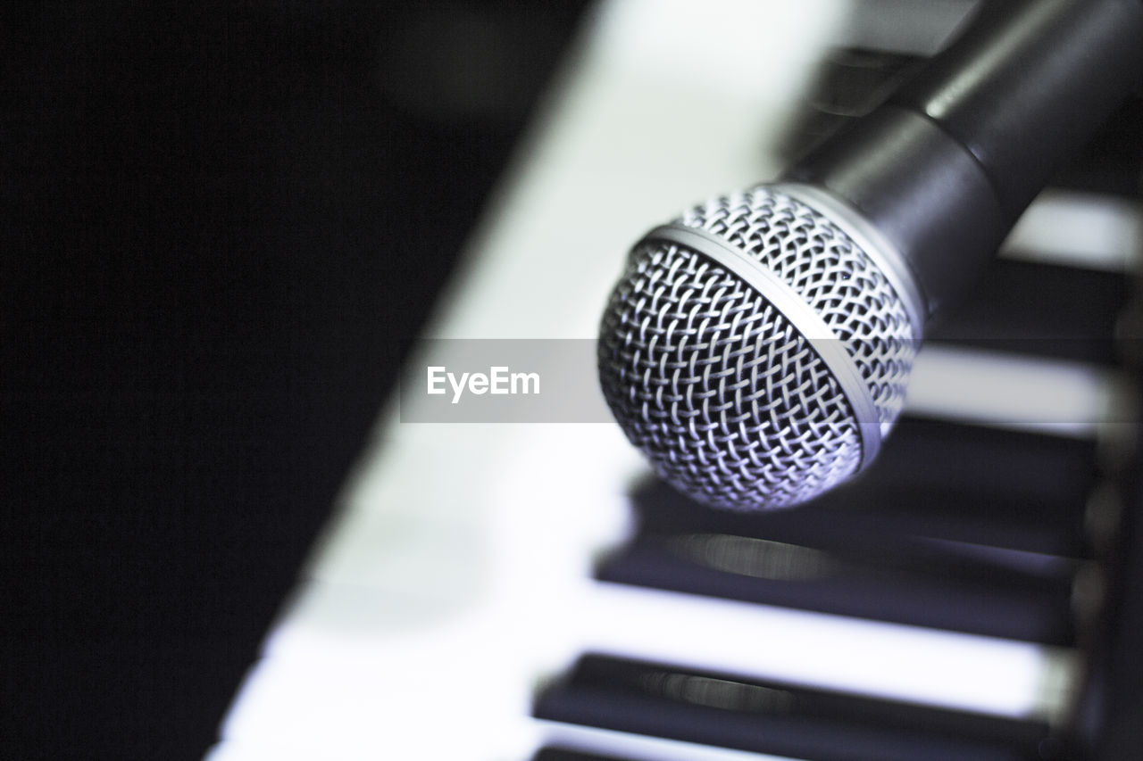 Microphone over piano keys in dim light. no people