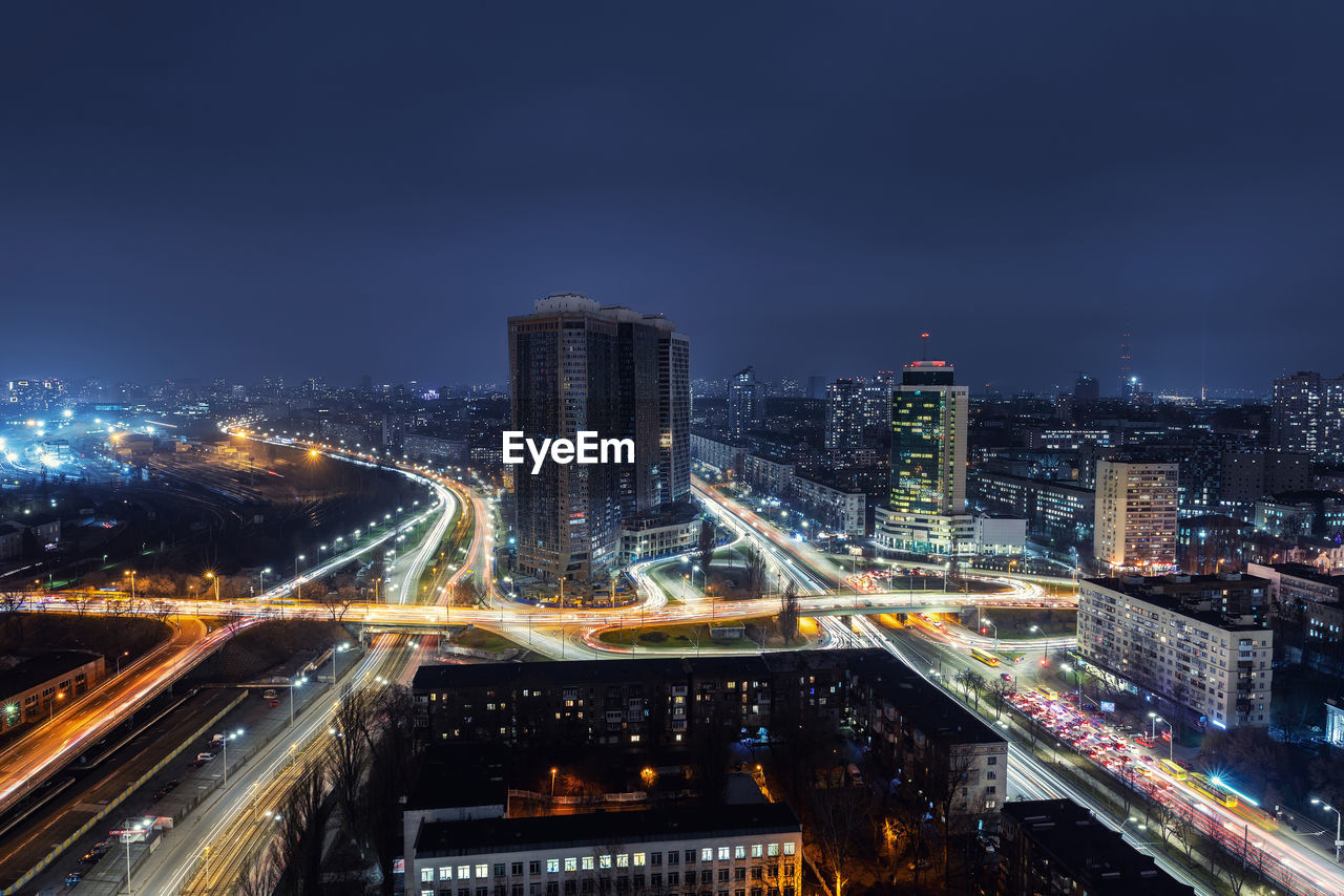 HIGH ANGLE VIEW OF ILLUMINATED CITY BUILDINGS AGAINST SKY