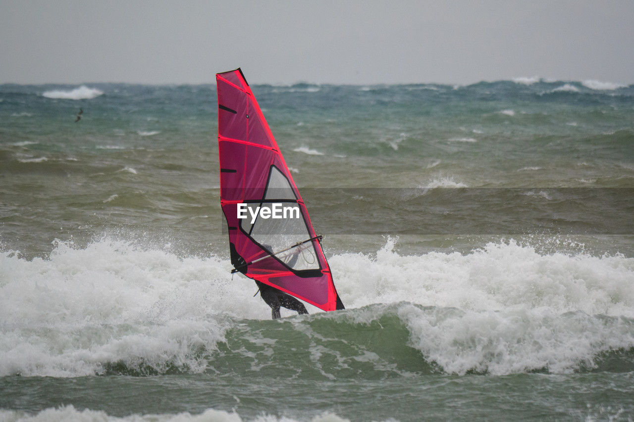 water, sports, wind wave, windsurfing, sea, motion, water sports, wave, sailing, wind, surfing, nature, boardsport, adventure, extreme sports, vehicle, leisure activity, beauty in nature, sign, outdoors, day, sky, sports equipment, warning sign, recreation, activity, speed, challenge, communication