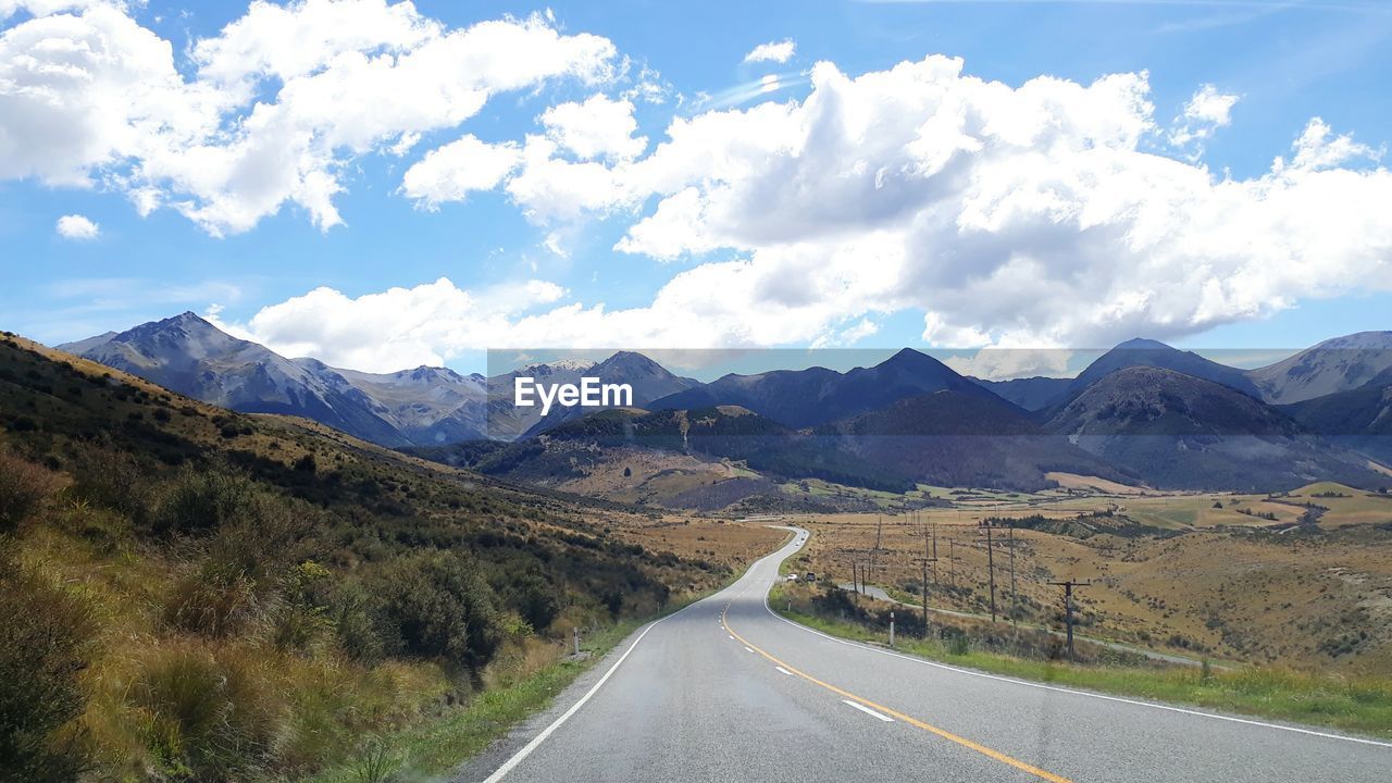 EMPTY ROAD LEADING TOWARDS MOUNTAINS