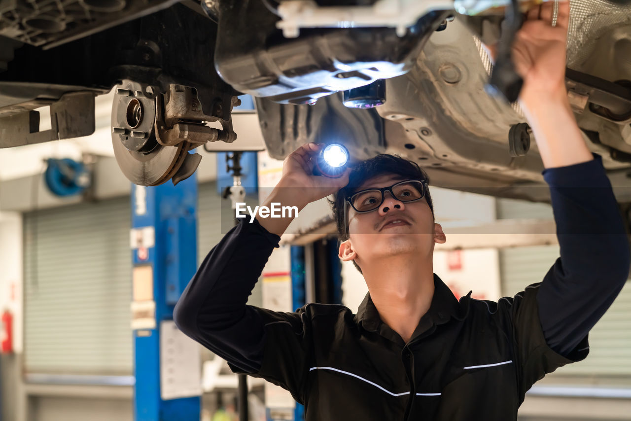 PORTRAIT OF YOUNG MAN WORKING IN INDUSTRY