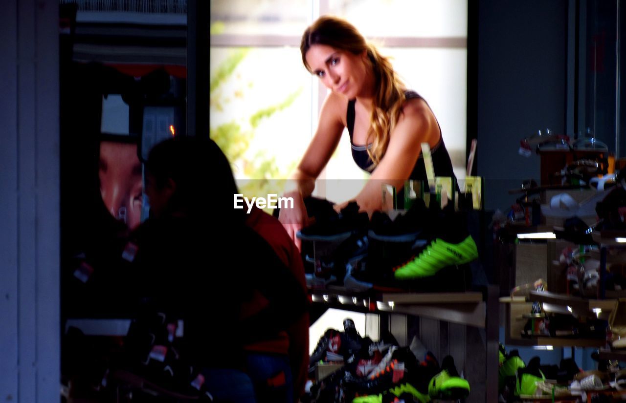 PORTRAIT OF A YOUNG WOMAN LOOKING AT STORE