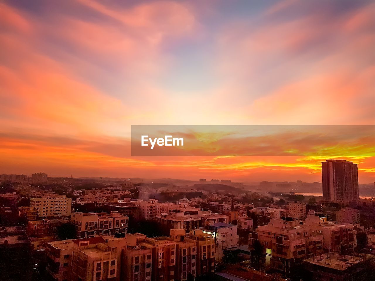 HIGH ANGLE SHOT OF TOWNSCAPE AGAINST ORANGE SKY