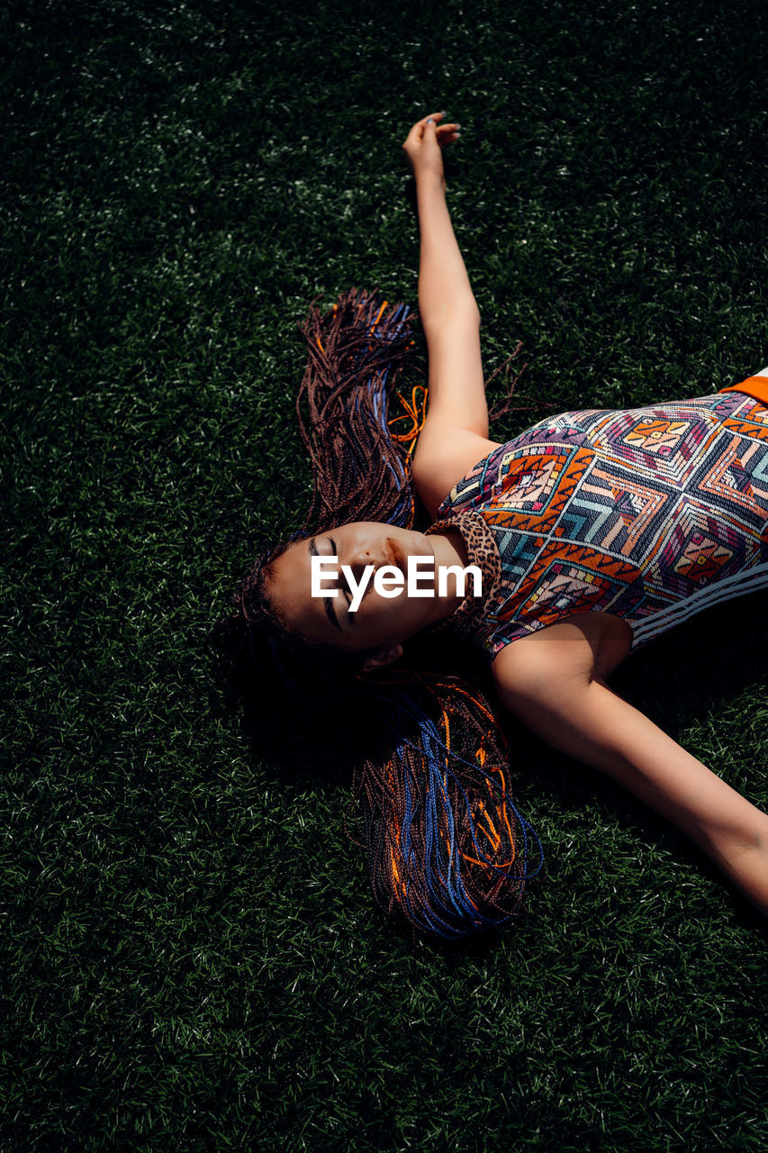 HIGH ANGLE VIEW OF WOMAN LYING ON GRASS