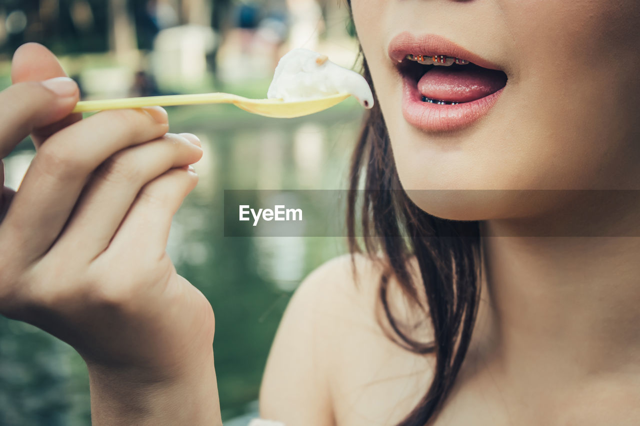 Close-up portrait of woman holding hands and she eatting i-cream