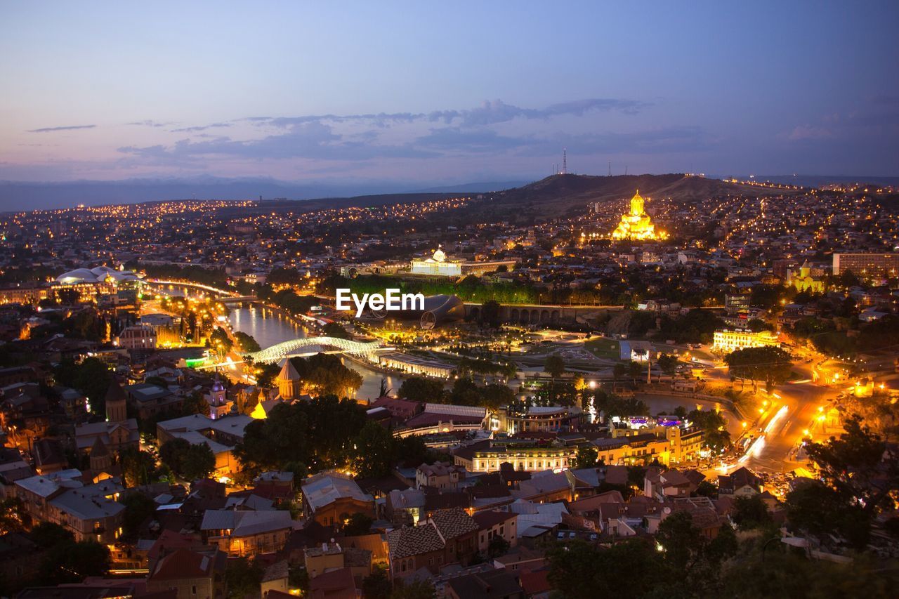 Illuminated townscape against sky during sunset