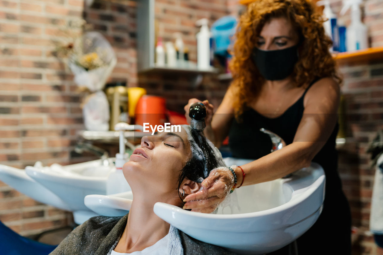 Woman in the hairdresser's shop shampooing her hair