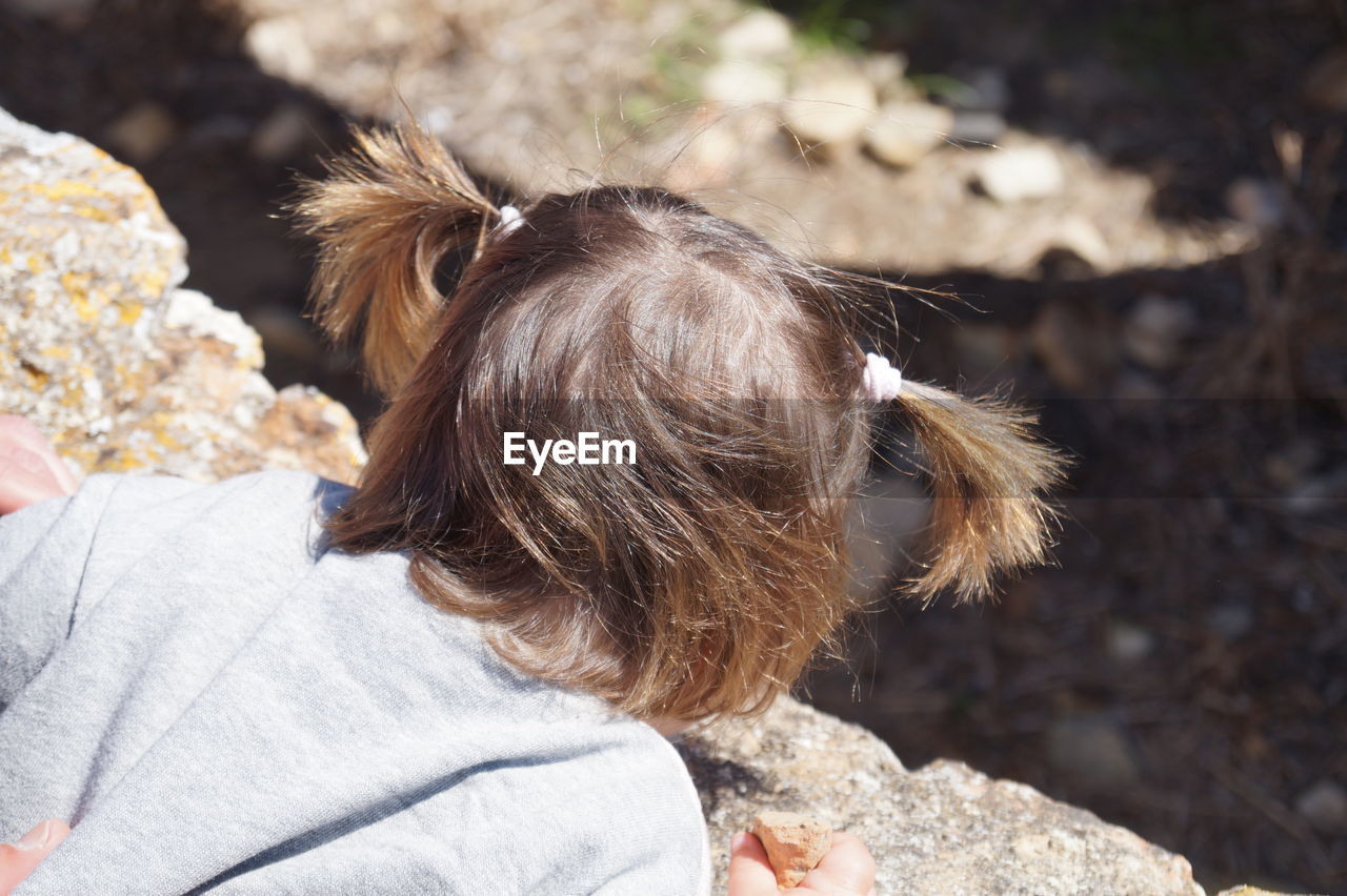 High angle view of girl leaning on retaining wall