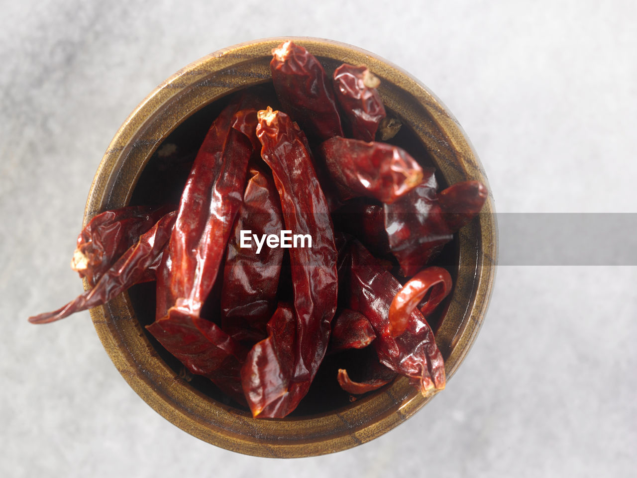 Directly above shot dry chili pepper in wooden container