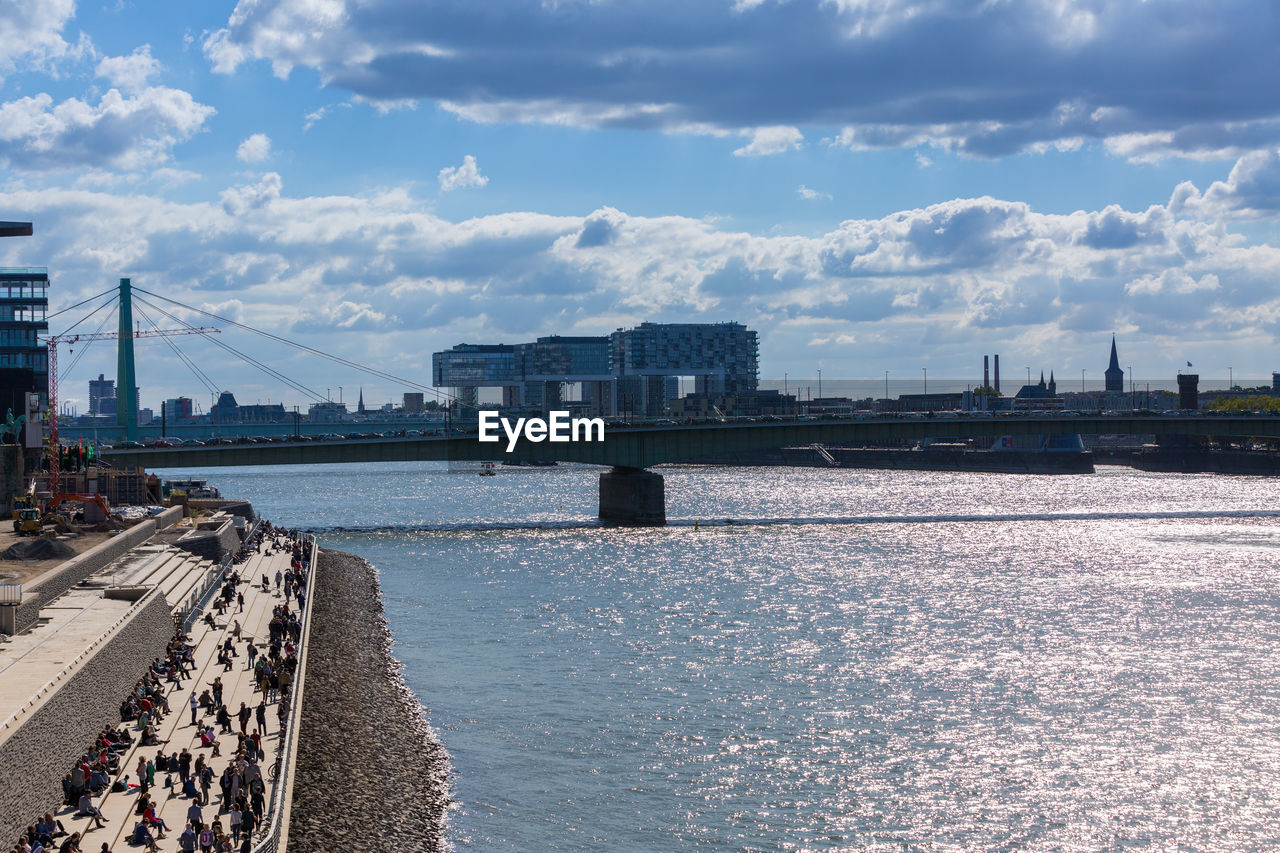 River against buildings and cloudy sky on sunny day