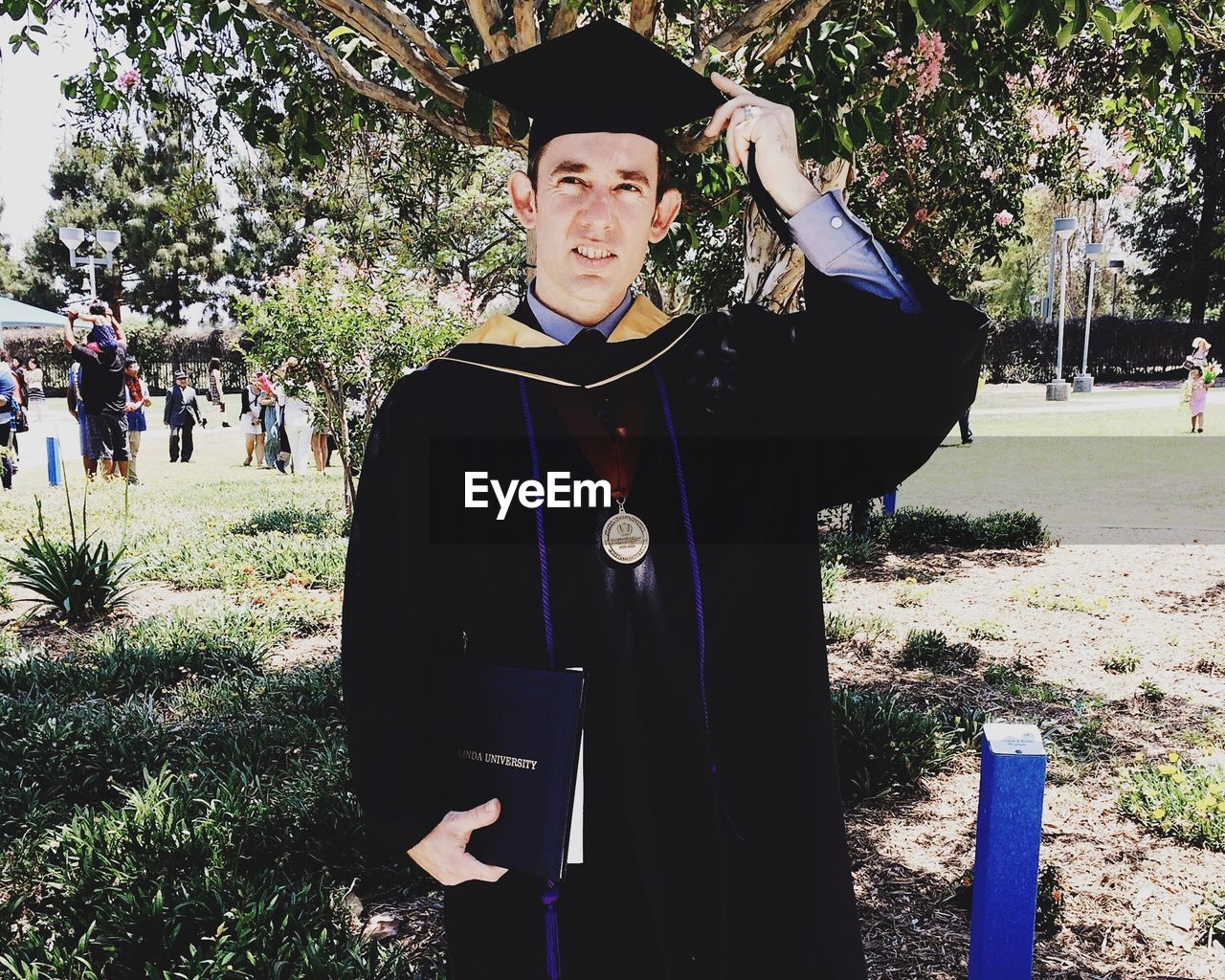 Man in graduation gown standing on land