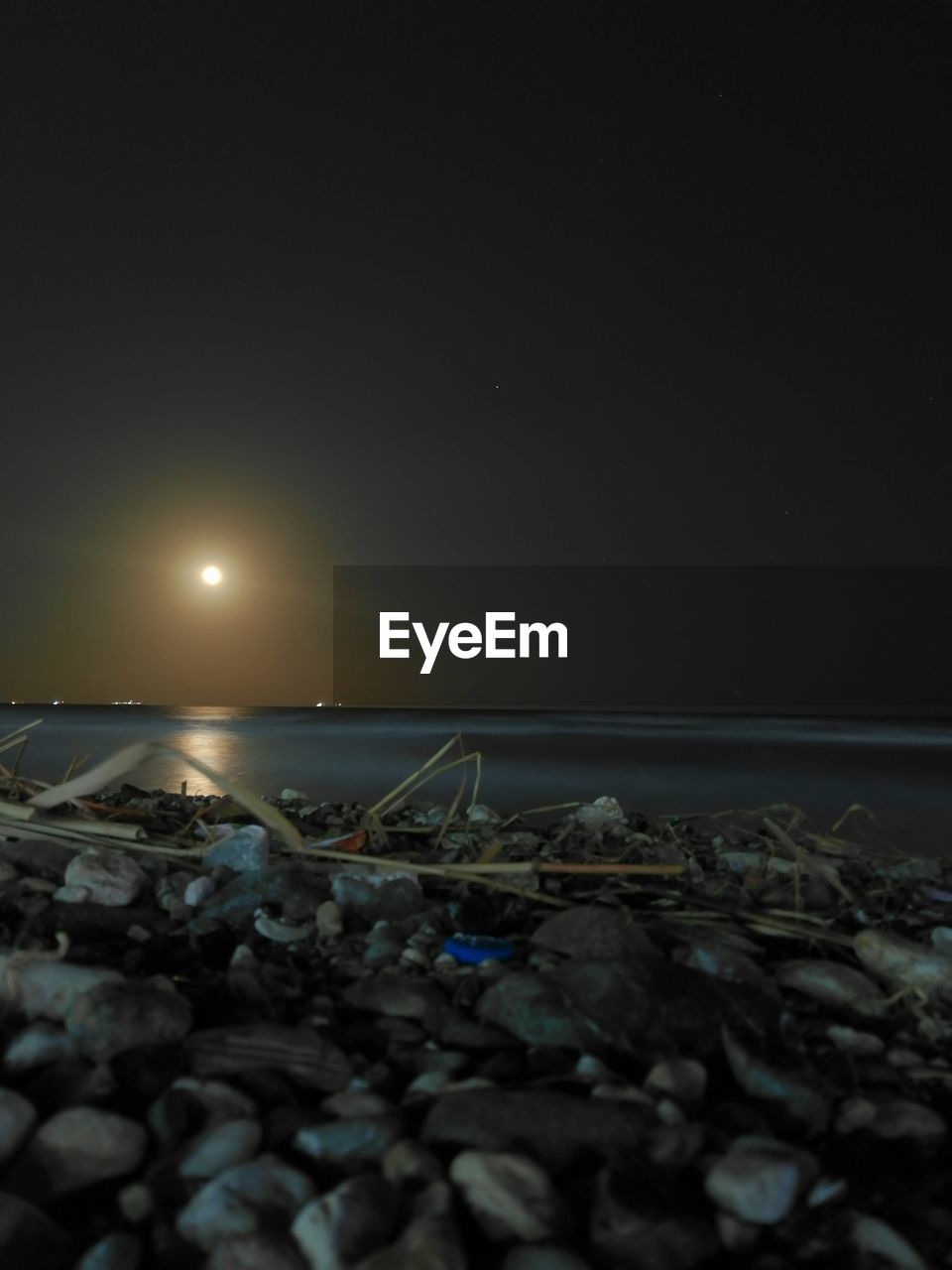 GARBAGE ON BEACH AGAINST SKY AT NIGHT