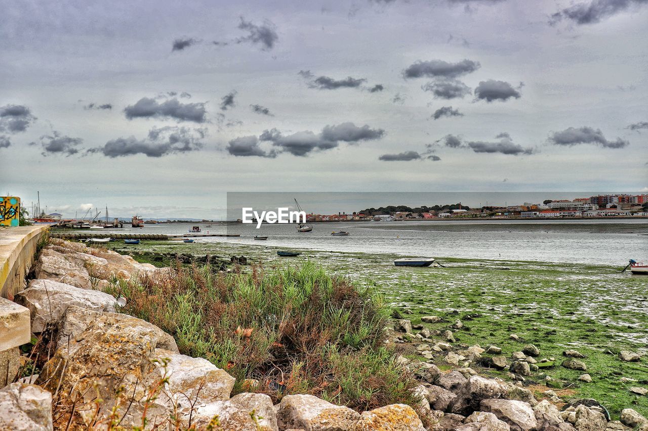 VIEW OF HARBOR AGAINST CLOUDY SKY