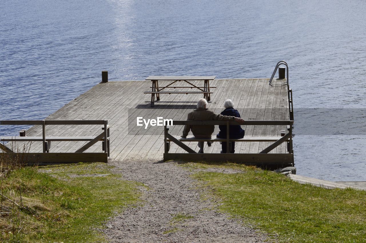 High angle view of men on railing by sea