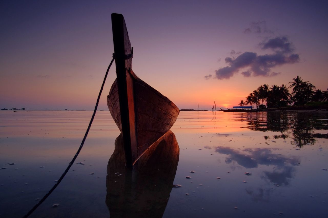 Idyllic view of boat on sea during sunset against sky