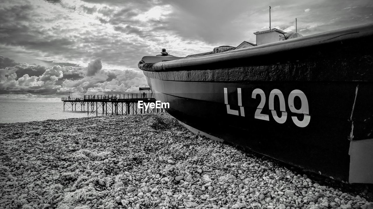 PIER ON BEACH AGAINST SKY