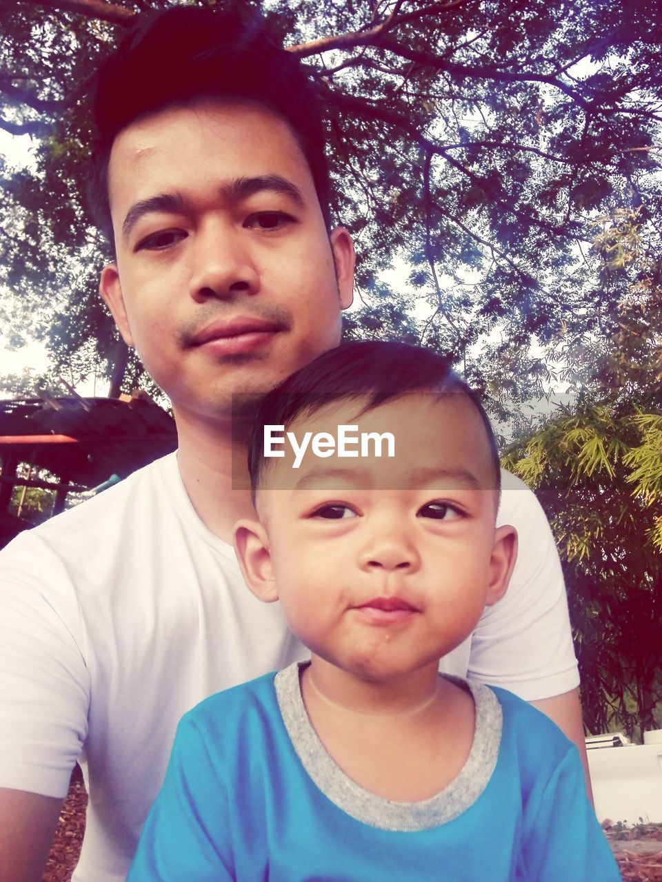 Portrait of father with son sitting outdoors