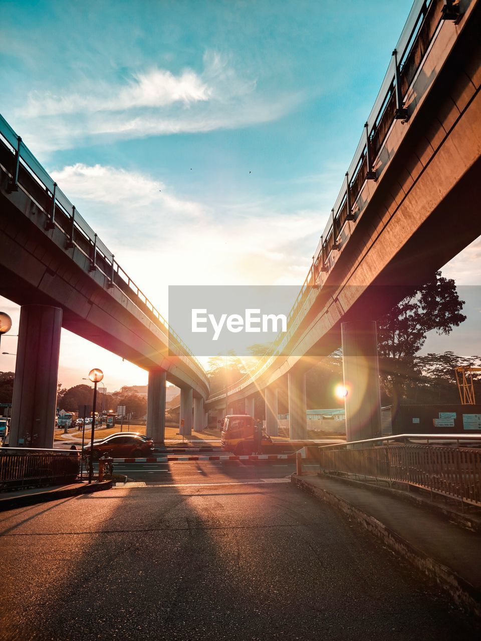 Low angle view of bridge in city against sky during sunset