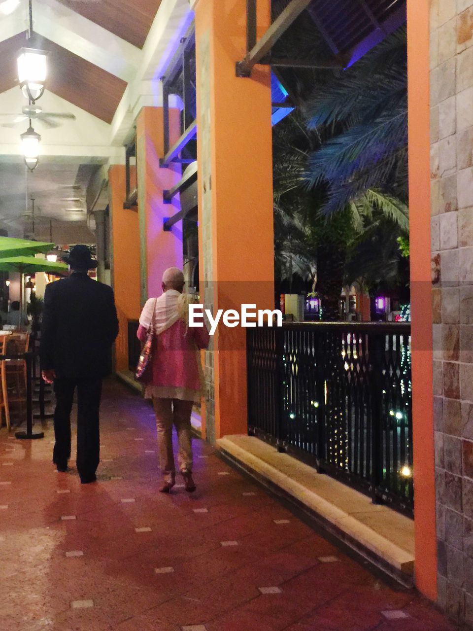 WOMAN STANDING IN ILLUMINATED CITY