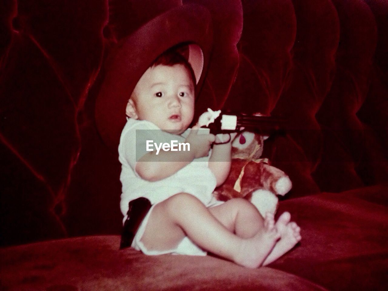 Close-up of a baby boy playing with a toy gun