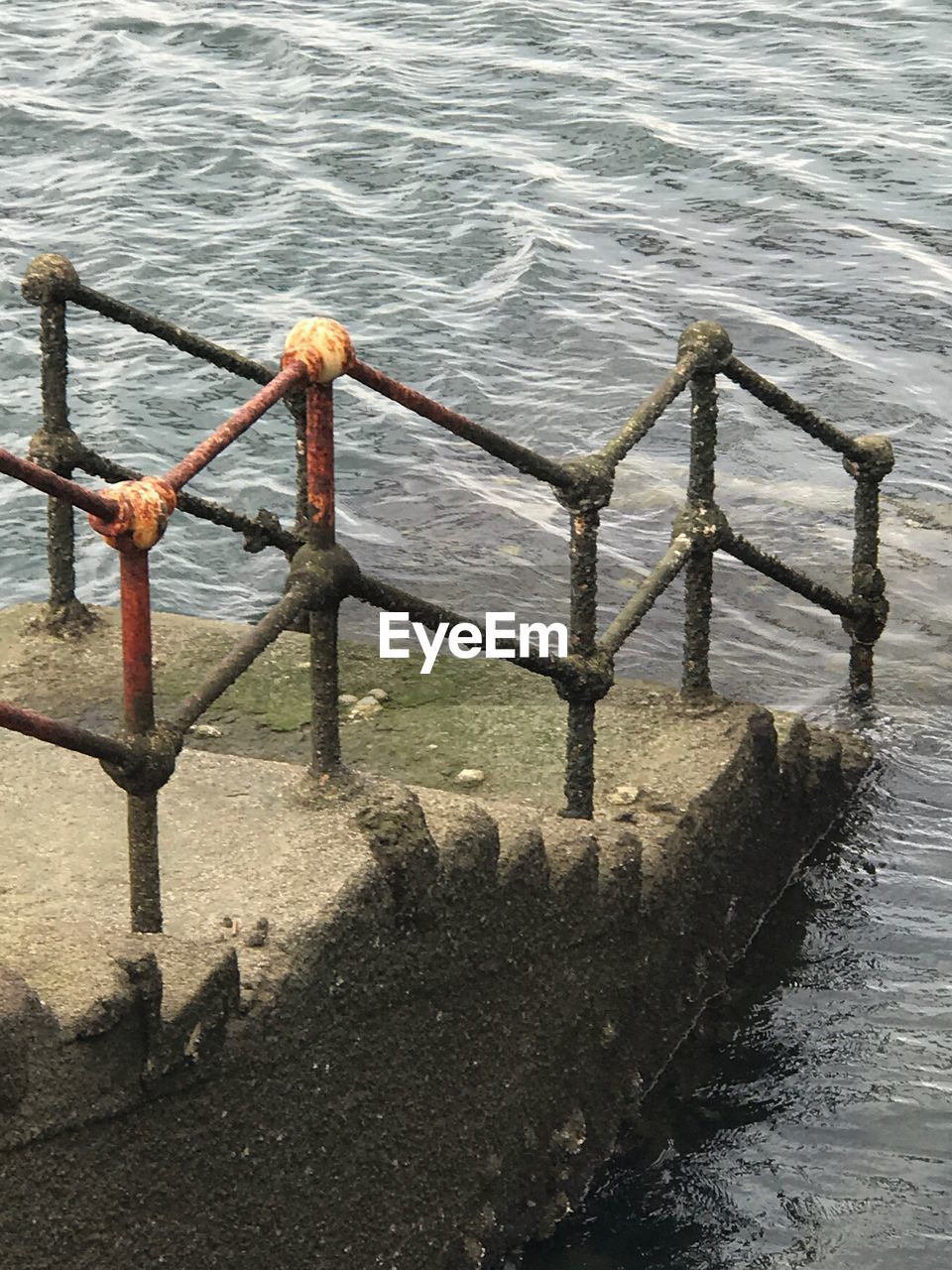 HIGH ANGLE VIEW OF RAILING IN SEA