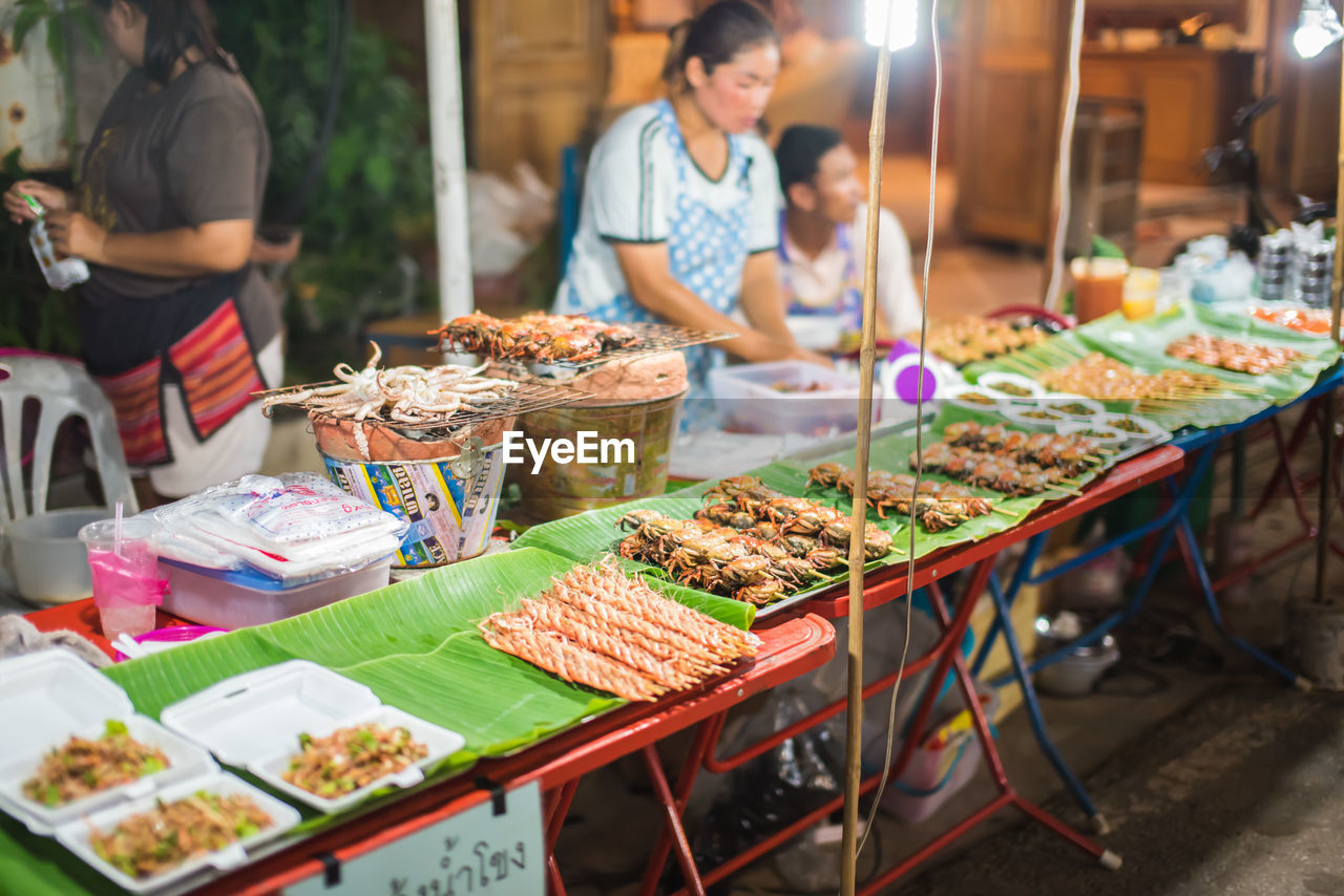 PEOPLE IN MARKET STALL