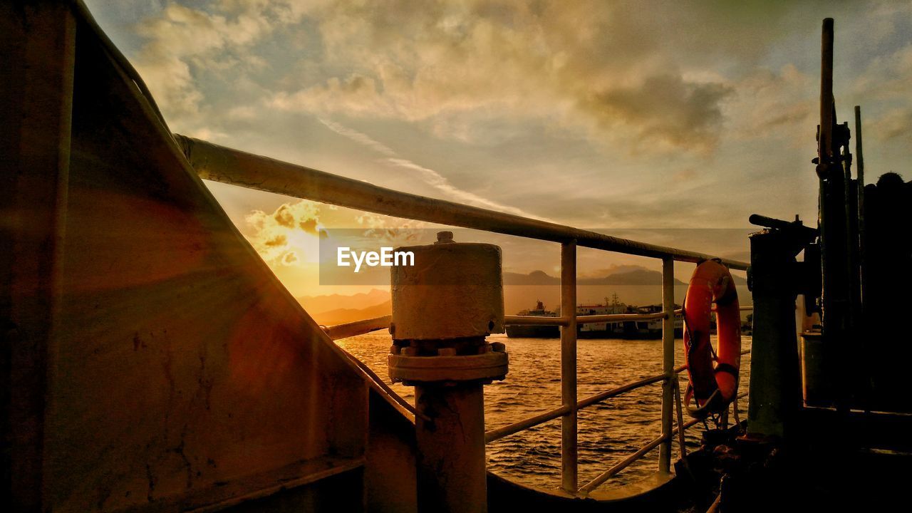 Bridge over sea against sky during sunset