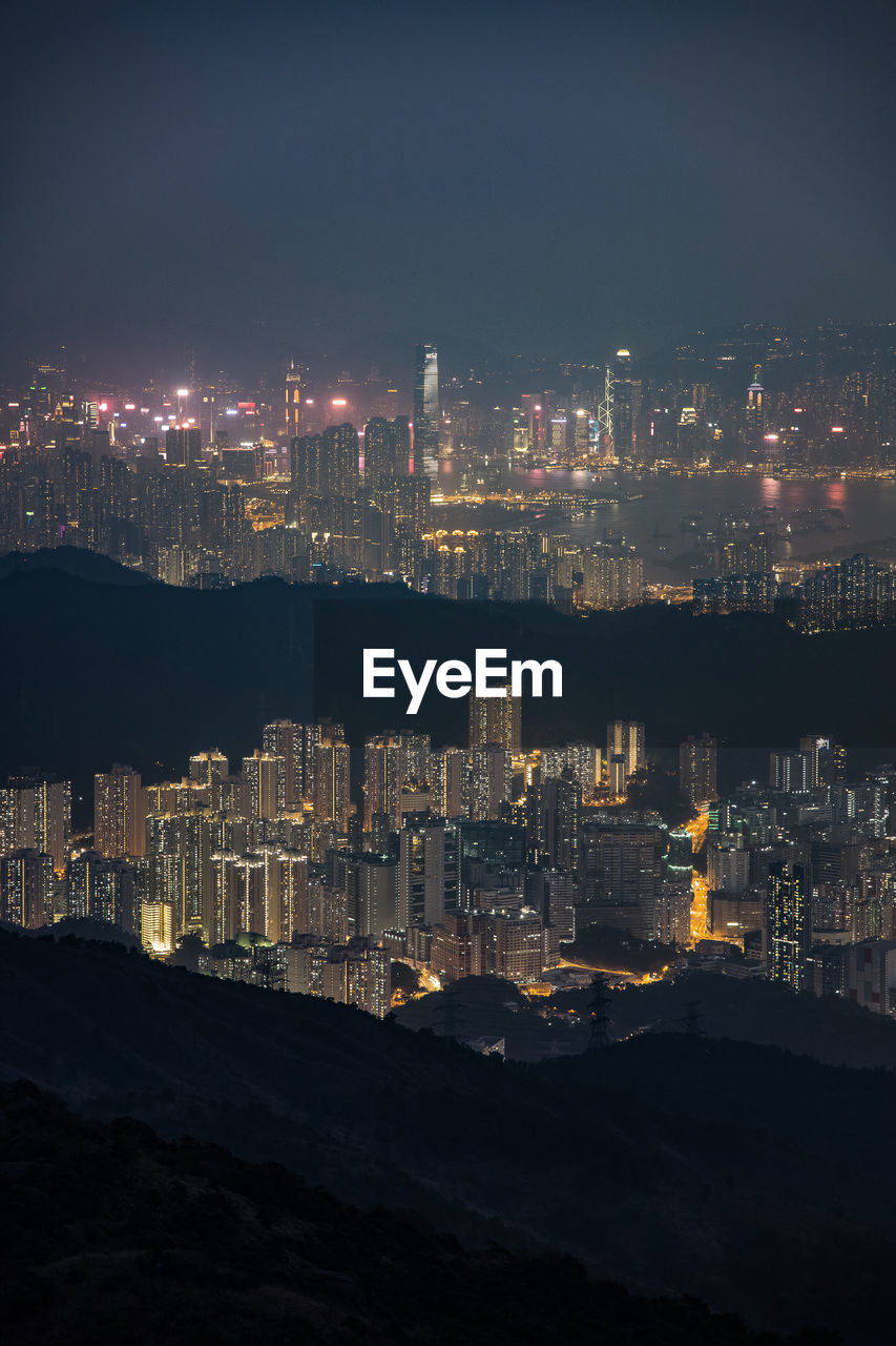 High angle view of illuminated buildings against sky at night