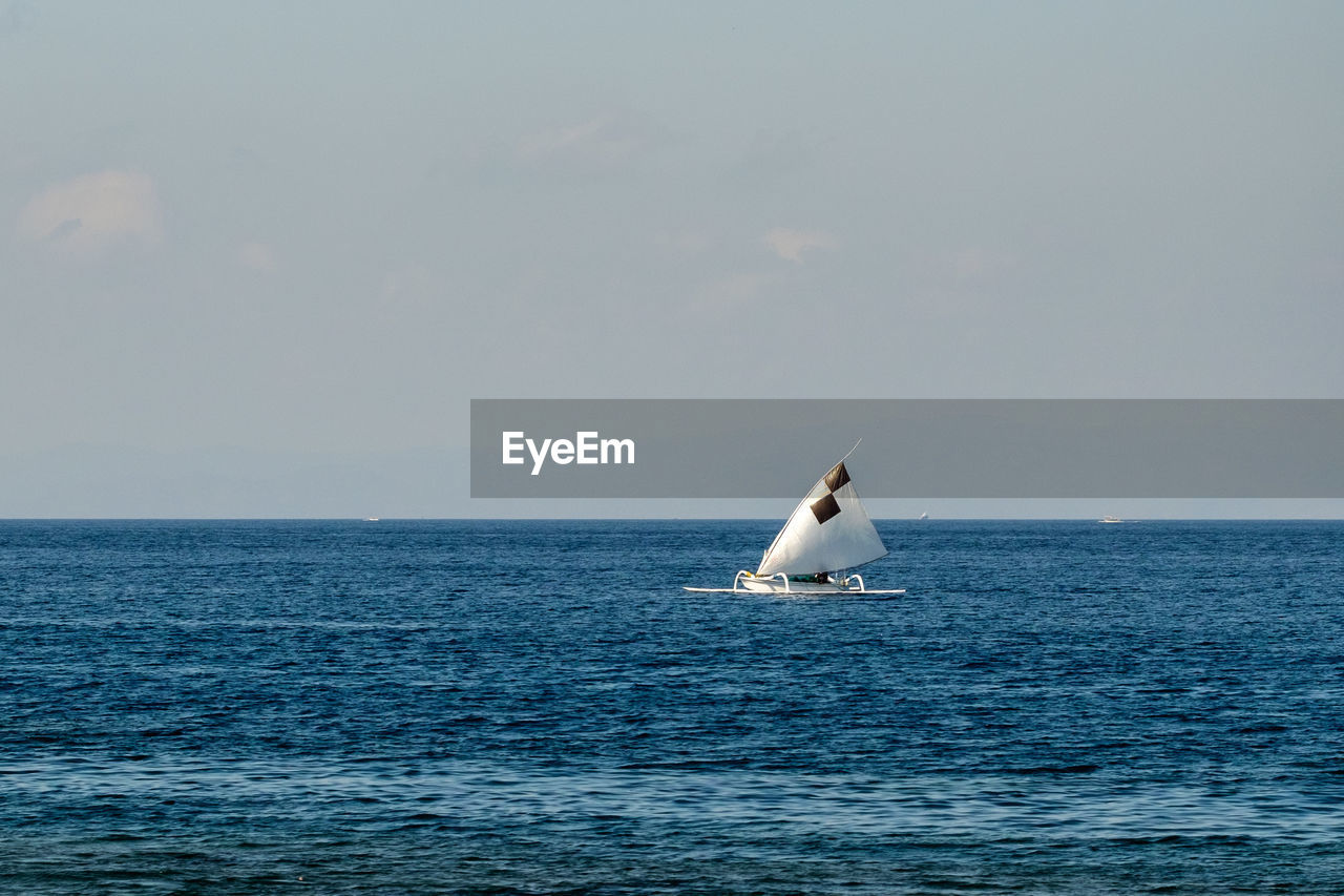 SAILBOAT IN SEA AGAINST CLEAR SKY