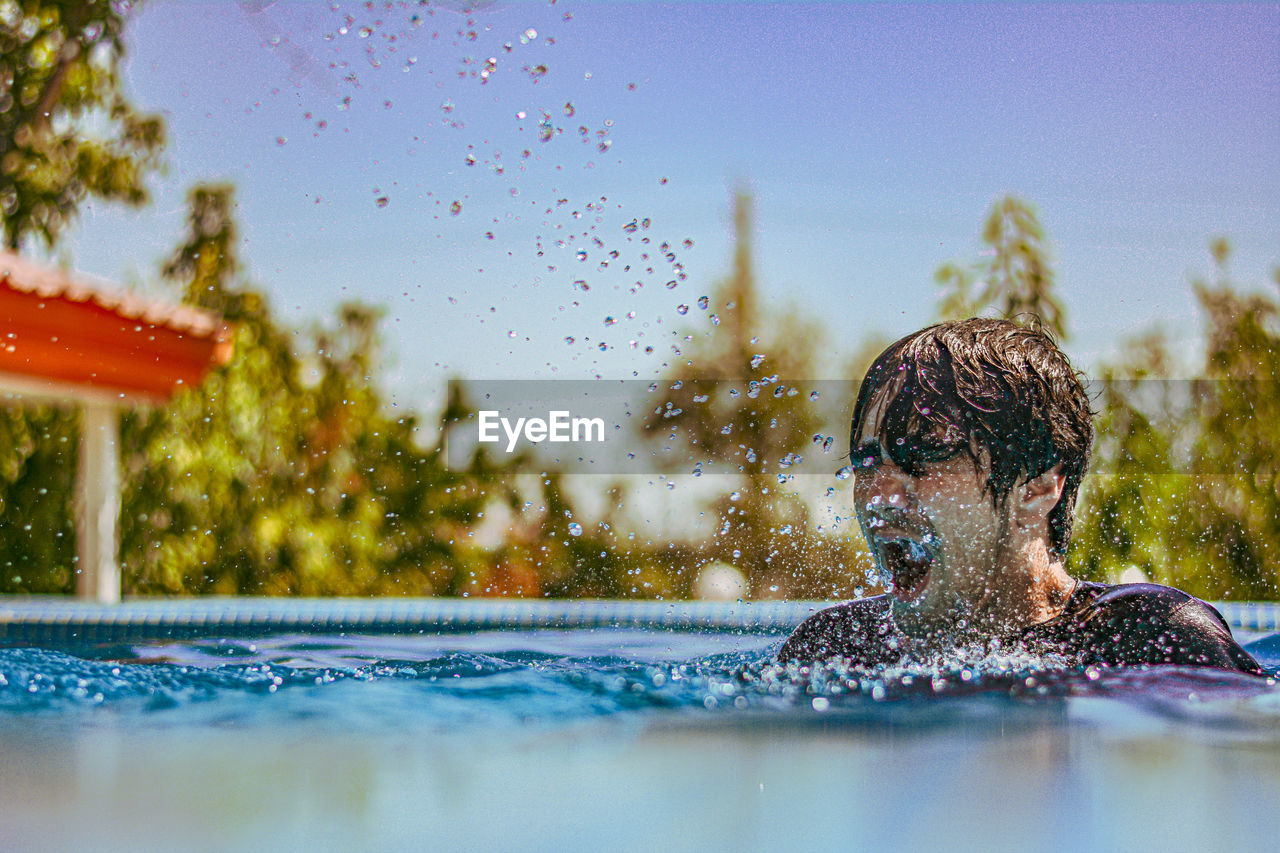 side view of man swimming in pool