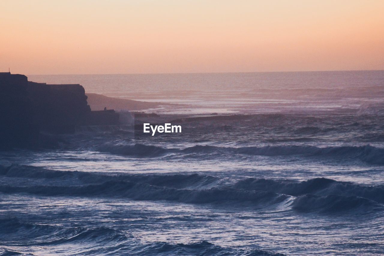 Scenic view of sea against clear sky during sunset