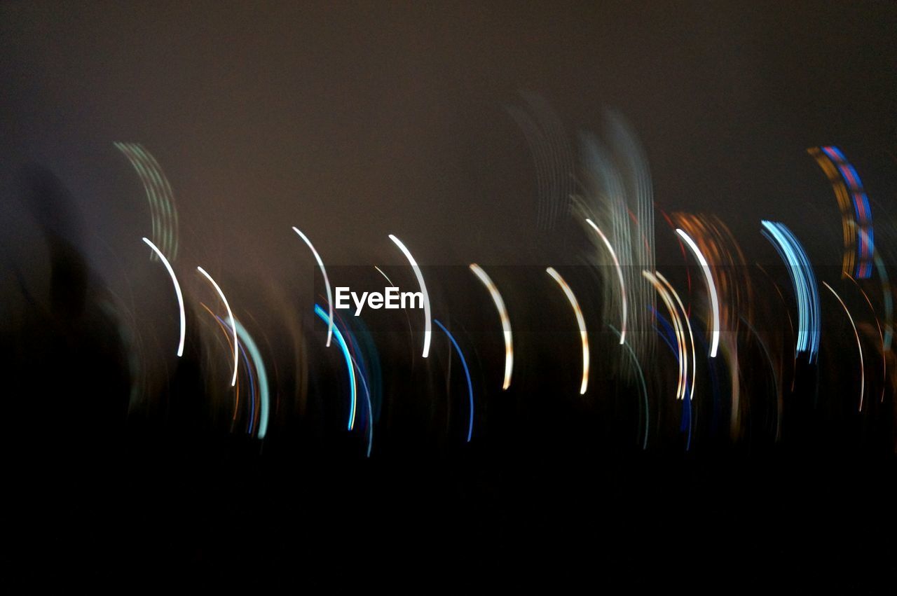 Low angle view of light trails against sky at night