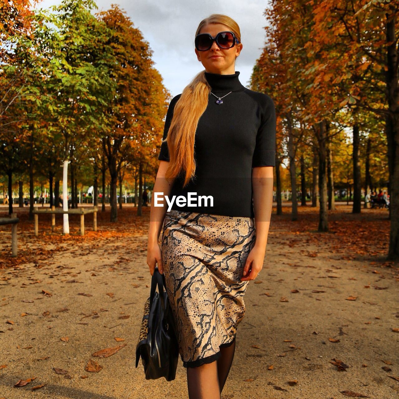 Young woman walking at park during autumn