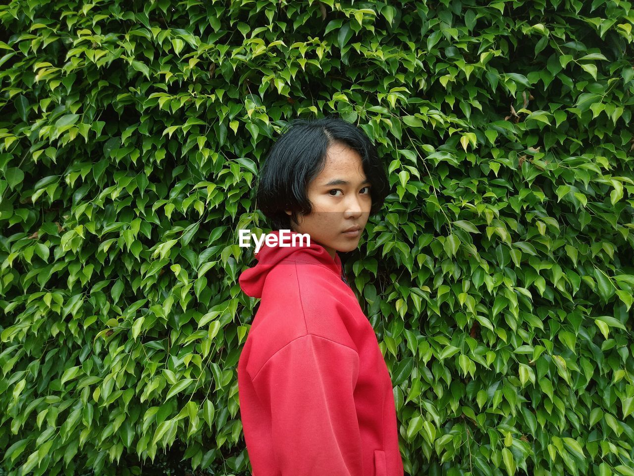 Side view portrait of woman standing by plants