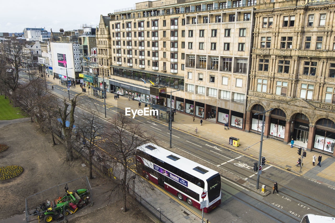 HIGH ANGLE VIEW OF CARS ON ROAD BY BUILDINGS