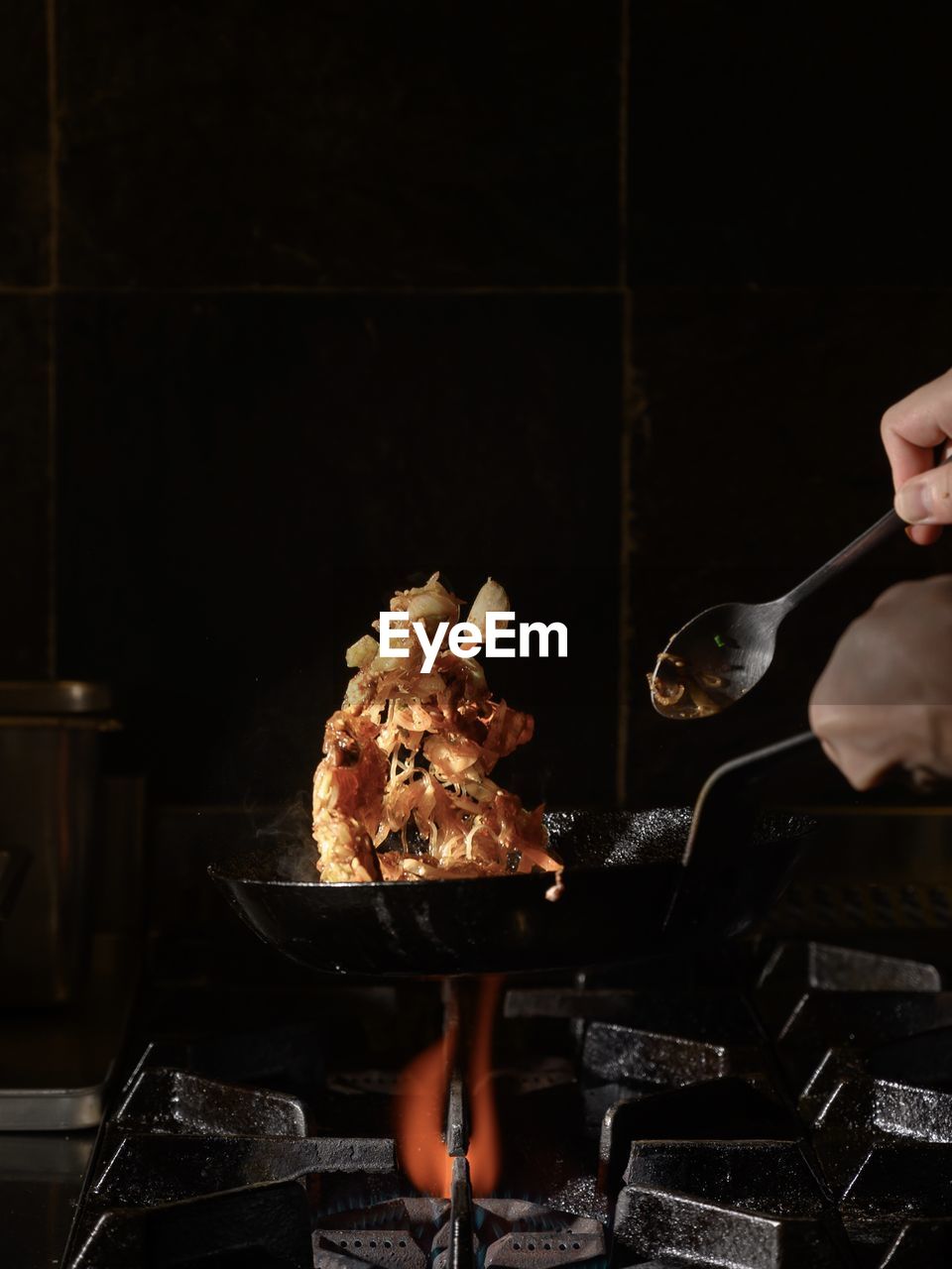 Person preparing food on barbecue grill